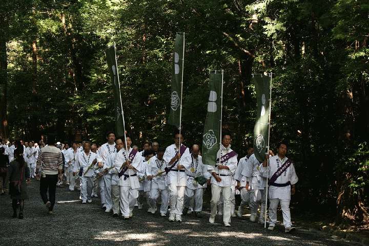 初穂を手に神域を進む